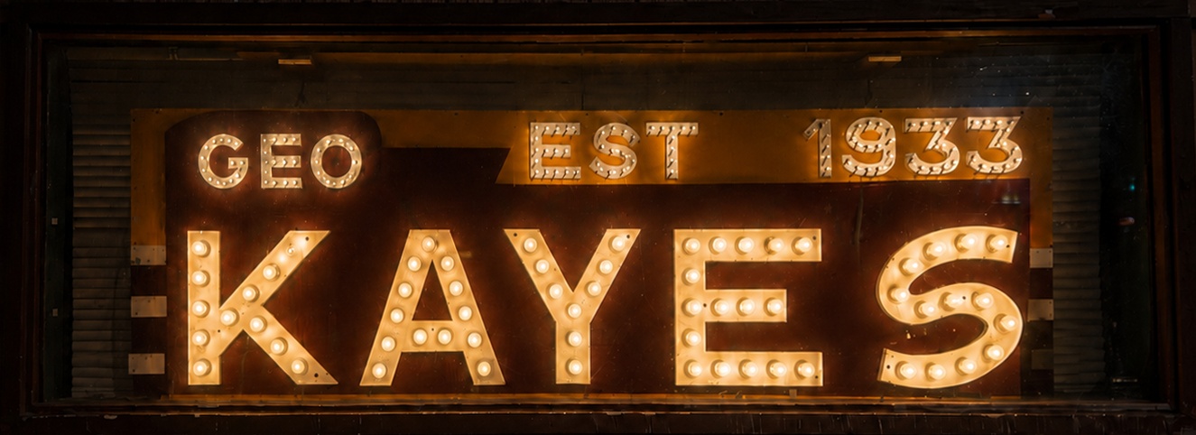 The lit GEO KAYE'S marquee sign glowing in the bar window — established 1933